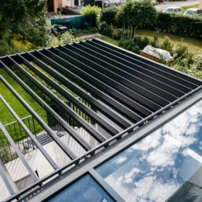 kombinirali-nadstresek-pergola-lameli-nadstresek-s-steklom-na-terasi-pred-vhodom Pogled od zgoraj na aluminijasto streho nadstreška nad vrtom