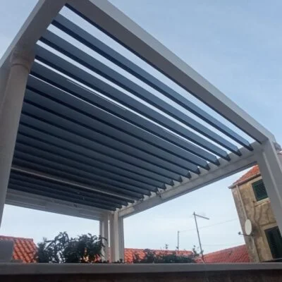 Bioklimatska pergola Agava z belo konstrukcijo in antracit lamelami na terasi