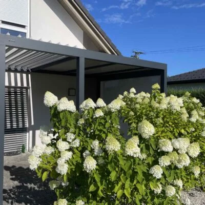 soltec-pergola-na-vrtu-terasa Bioklimatska pergola ob hiši s cvetočimi hortenzijami na vrtu